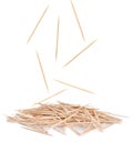 Wooden toothpicks falling into pile on white background