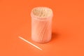 Wooden toothpicks and holder on orange background