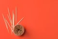 Wooden toothpicks and holder on red background, flat lay. Space for text