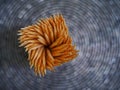 Wooden toothpicks in a square holder, Top view, Blurred round pattern background