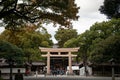 Wooden Torii gate of Meiji Jingu Shrine under big tree in Tokyo Royalty Free Stock Photo