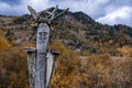 Wooden totem pillar on mountains background in autumn. Orthodox old believers totem.