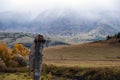 Wooden totem pillar on mountains background in autumn. Orthodox old believers totem.