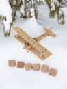 A wooden toy airplane in the snow, against the background of a forest and the word Russia made up of cubes. The concept of Royalty Free Stock Photo