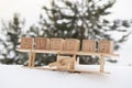 A wooden toy airplane in the snow, against the background of a forest and the word Russia made up of cubes. The concept Royalty Free Stock Photo