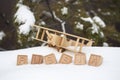 A wooden toy airplane in the snow, against the background of a forest and the word Russia made up of cubes. The concept Royalty Free Stock Photo