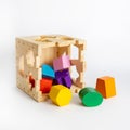 Wooden toy blocks cube shape sorter, colorful details isolated on white background, early development of logic for