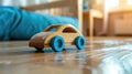 Wooden toy car with blue wheels on a hardwood floor Royalty Free Stock Photo