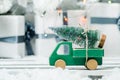 Wooden toy car carrying a christmas tree on shiny lights background Royalty Free Stock Photo