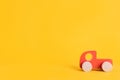 Wooden toy car in cartoon style on yellow background. Colorful and Transportation background, eco kid toys Montessori . Royalty Free Stock Photo