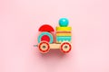 Wooden toy car with colorful blocks on pink background Royalty Free Stock Photo