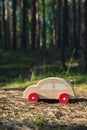 Wooden toy car on greenery forest background. Eco-car concept World car free day electric vehicle environment automobile