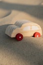 Wooden toy car on sandy beach background. Eco-friendly travel, reduce carbon footprints, environmental impact, Conscious