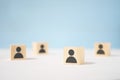 Wooden toy cubes with painted men stand apart from each other