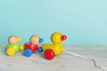 Wooden toy ducks a kids toy to pull around against a blue background with space for copy