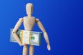 Wooden toy figure with money on blue Royalty Free Stock Photo