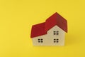 Wooden toy house on yellow background top view. House model