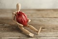 Wooden toy man holds a heart. Donor and transplant, symptoms of an attack. Surgical Assistance