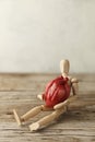 Wooden toy man holds a heart. Donor and transplant, symptoms of an attack. Surgical Assistance