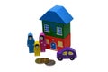 Wooden toy people, a house and car near the metal coins. Isolated over white background. Royalty Free Stock Photo