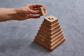 Wooden toy pyramid with geometric shapes. Hand faceless