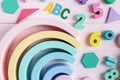 Wooden toy rainbow, numbers, blocks, pastel color arc on pink background. Natural no plastic toys for creativity development. Royalty Free Stock Photo