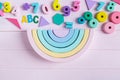 Wooden toy rainbow, numbers, blocks, pastel color arc on pink background. Natural no plastic toys for creativity development. Royalty Free Stock Photo