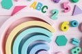 Wooden toy rainbow, numbers, blocks, pastel color arc on pink background. Natural no plastic toys for creativity development Royalty Free Stock Photo