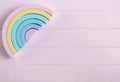 Wooden toy rainbow, pastel color arc on light pink background. Natural no plastic toys for creativity development. Royalty Free Stock Photo