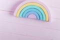 Wooden toy rainbow, pastel color arc on light pink background. Natural no plastic toys for creativity development. Royalty Free Stock Photo