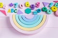 Wooden toy rainbow, pastel color arc on light pink background. Natural no plastic toys for creativity development. Royalty Free Stock Photo