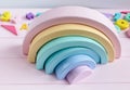 Wooden toy rainbow, pastel color arc   on light pink background. Natural  no plastic toys for creativity development. Royalty Free Stock Photo