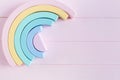 Wooden toy rainbow, pastel color arc   on light pink background. Natural toys for creativity development. Royalty Free Stock Photo