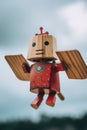 A wooden toy with a red shirt and wings. Generative AI image.