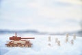 A wooden toy Russian tank T-34 and little men in the snow. Russia and Ukraine are at war in winter. Encirclement Royalty Free Stock Photo