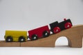 Wooden toy train crossing track bridge. Transportation concept Royalty Free Stock Photo