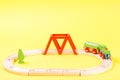 Wooden toy train set on tracks on yellow background. Royalty Free Stock Photo