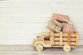 Wooden toy truck with gift boxes in the back on a white wooden b Royalty Free Stock Photo