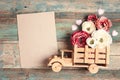 Wooden toy truck with peonies flowers in the back and blank sheet of brown paper on shabby wooden turquoise boards Royalty Free Stock Photo