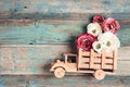 Wooden toy truck with peonies flowers in the back on shabby wooden turquoise boards. Space for text Royalty Free Stock Photo