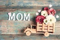 Wooden toy truck with peonies flowers in the back and word MOM on wooden turquoise boards Royalty Free Stock Photo