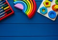 Wooden toys, calculation rack, shape sorter board on classic blue background. Back to school background. Close up. Top view, Royalty Free Stock Photo