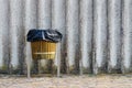 Wooden trash bin at gray concrete wall