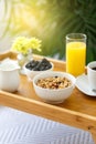 Wooden tray with breakfast on the bed