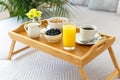 Wooden tray with breakfast on the bed