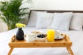 Wooden tray with breakfast on the bed