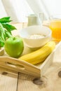 Wooden Tray with Healthy Breakfast Ingredients on Table. Oats in Bowl Nut Milk in Pitcher Orange Juice Banana Green Apple Royalty Free Stock Photo