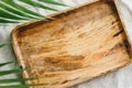 Wooden tray is made from mango tree on a linen cloth decorated palm leaf