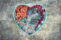 Wooden tray in the shape of a heart filled with women`s jewelry. Royalty Free Stock Photo