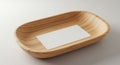 A wooden tray with smooth, light grain patterns features a rectangular, white card pla Royalty Free Stock Photo